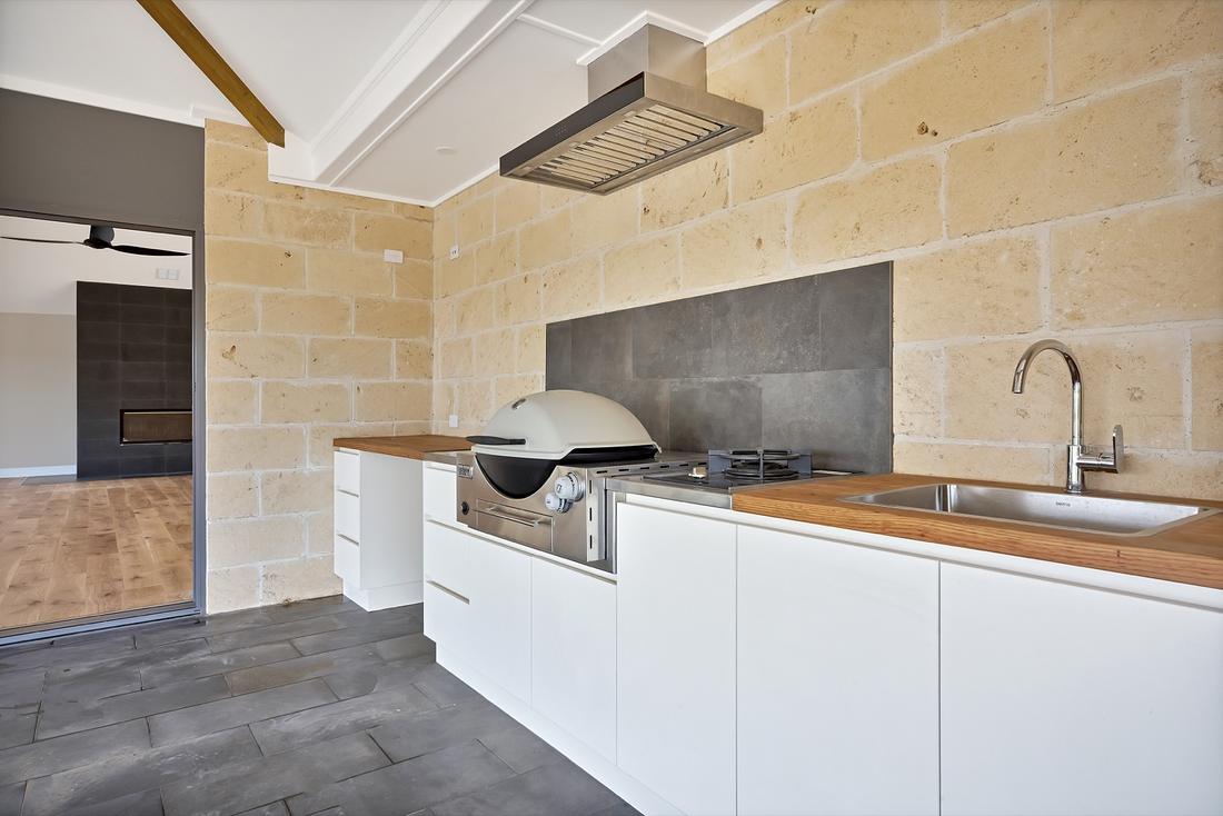 Outdoor kitchen with a built-in gas barbecue, benchtop and sink