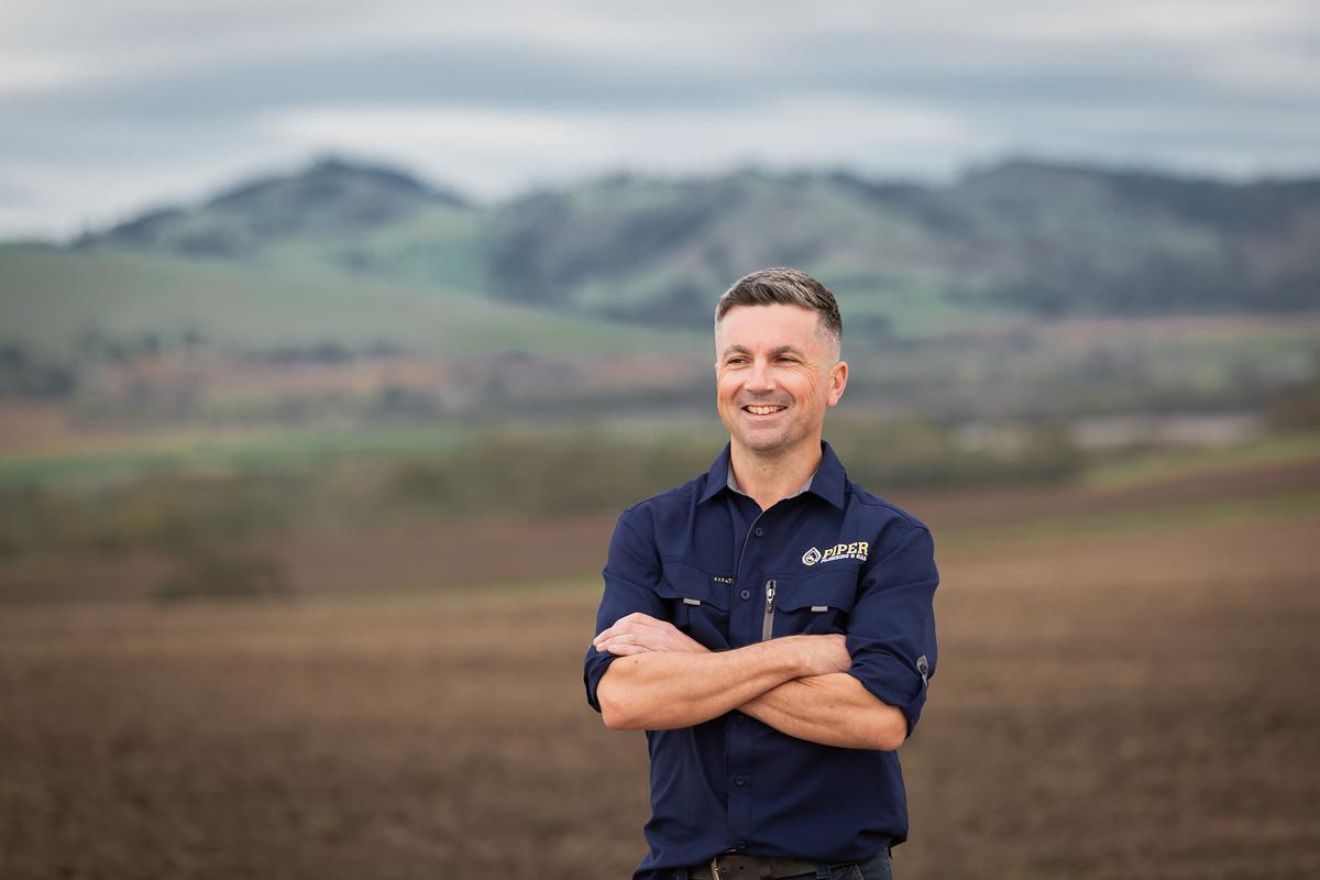 Craig MacDonald from Piper Plumbing & Gas standing in a paddock with the Barossa hills behind