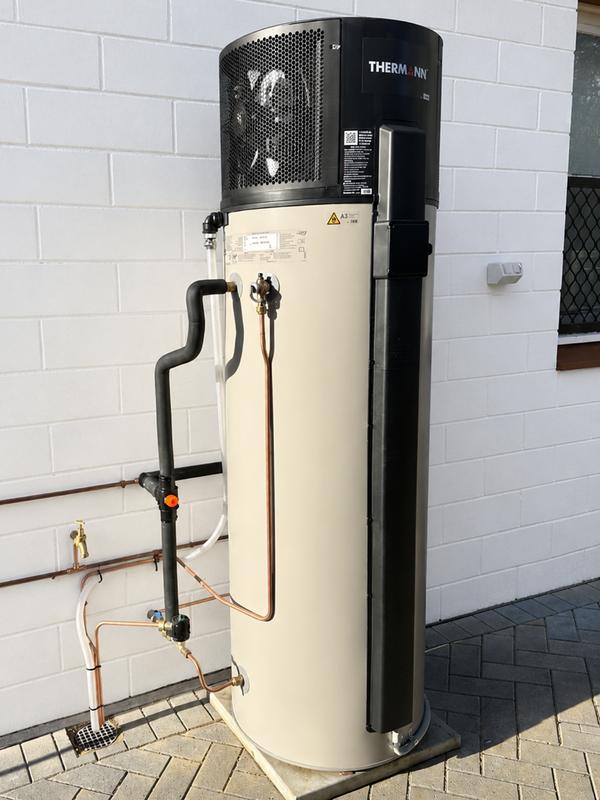 Heat pump hot water system installed beside a house
